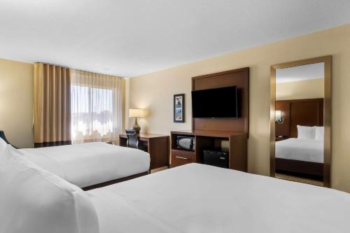 a hotel room with two beds and a mirror at Comfort Inn & Suites Greeley in Greeley