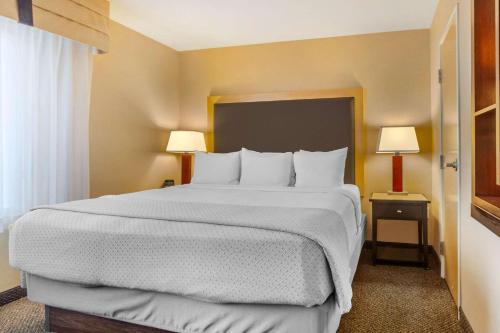 a large bed in a hotel room with two lamps at Cambria Hotel Ft Collins in Fort Collins