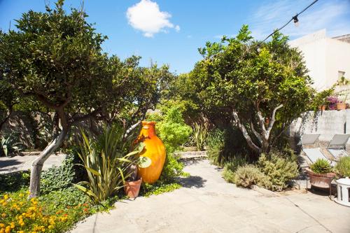 a large orange vase sitting in the middle of a garden at Wp RELAIS LOCANDA FIORE DI ZAGARA in Diso
