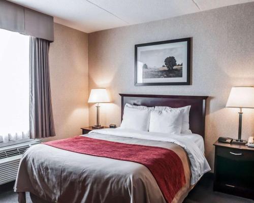 a hotel room with a bed and a window at Comfort Inn in Mississauga