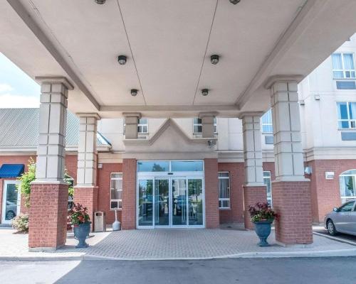 a large building with columns and a glass door at Comfort Inn in Mississauga
