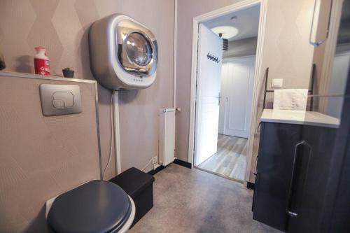 Elle comprend une petite salle de bains avec toilettes et une télévision. dans l'établissement Appartement Le Bel Air - balcon et parking gratuit, à Annecy