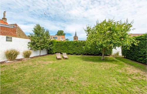 two benches sitting in a yard with a tree at Bébèr in Lombardsijde