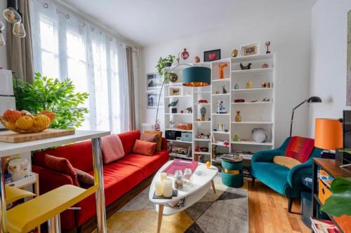 un salon avec un canapé rouge et une table dans l'établissement Charming quiet apartment near Montmartre, à Paris