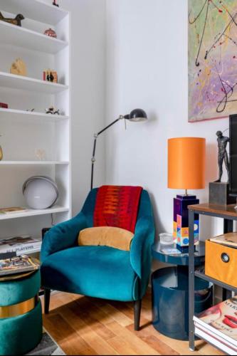 un salon avec une chaise bleue et un bureau dans l'établissement Charming quiet apartment near Montmartre, à Paris