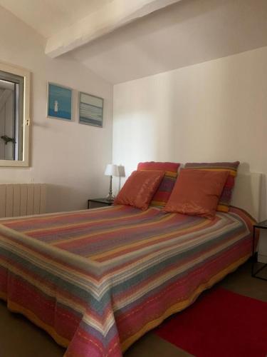 une chambre avec un grand lit avec une couverture colorée dans l'établissement Villa Faro, à Laouque