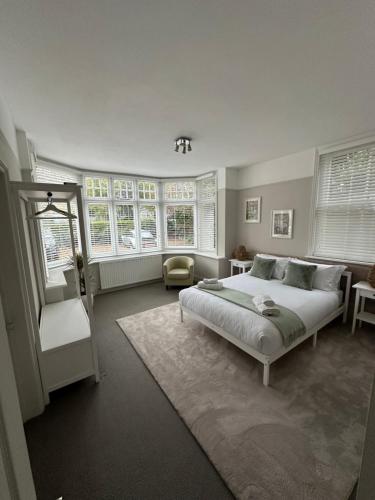 a bedroom with a bed and some windows at Woodfalls Luxury Getaway in Bournemouth