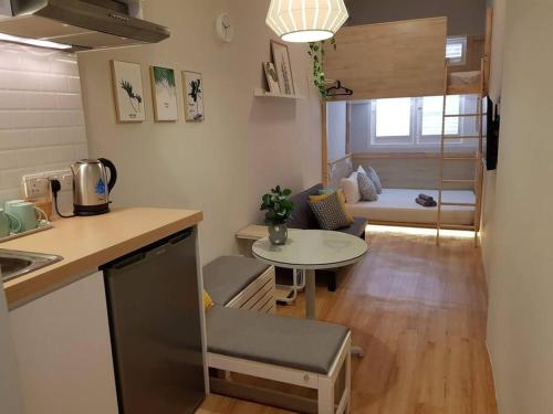 Heritage Loft on Beach Street near UNESCO Zone & Street Art 3 في جورج تاون: مطبخ صغير وغرفة معيشة مع طاولة صغيرة