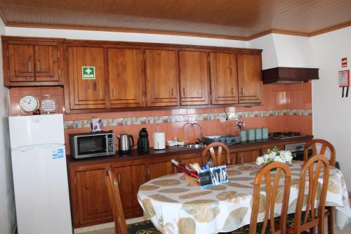 a kitchen with a table and a white refrigerator at Nordesteza House in Nordestinho