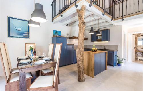 Una cocina y comedor con gabinetes azules y una mesa de madera. en Gorgeous Home In Jurdani, en Mučići
