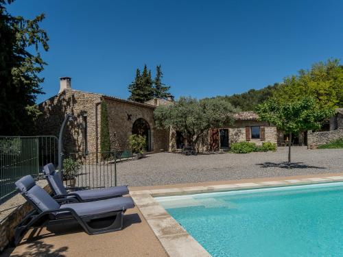 a pair of lounge chairs sitting next to a swimming pool at Le Ponant in Vaison-la-Romaine