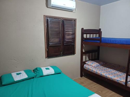 バヘイリーニャスにあるCasa em Barreirinhas em frente ao Rio Preguiçasの二段ベッド2台と窓のある寝室