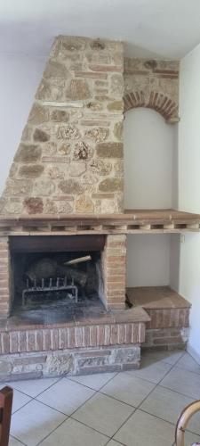 a brick fireplace in a room with a stone wall at Il Vignale in Massa Martana