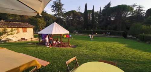 a group of people sitting under a tent in a yard at Il Vignale in Massa Martana