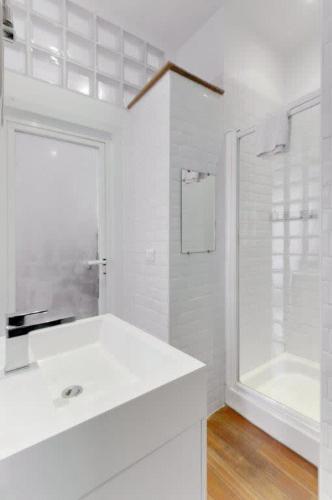 une salle de bain blanche avec un lavabo et une douche dans l'établissement Rue Fodere location Port area, à Nice