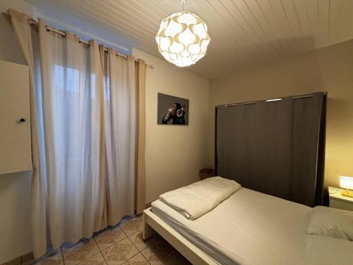 a bedroom with a bed and a chandelier at Appartement Sabail 2 - T2 spacieux in Bègles