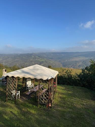 a tent with a table and chairs in a field at La corte dei celti -1 in San Benedetto Del Querceto