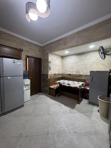 a kitchen with a refrigerator and a bed in a room at El Narges fully furnished apartment for rent new cairo in Cairo
