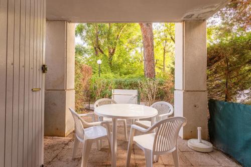 une table blanche et des chaises sur une terrasse dans l'établissement Appartement Le Lavandou - Cavalière, au Lavandou