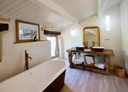 une salle de bain avec une baignoire et un miroir dans l'établissement Mas St Joseph, à Châteauneuf-Val-Saint-Donat