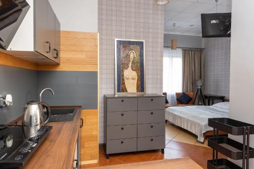 a kitchen with a sink and a room with a bed at Apartamenty Komfort in Częstochowa