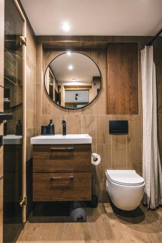 a bathroom with a sink and a toilet and a mirror at Drey Divcibare in Divčibare
