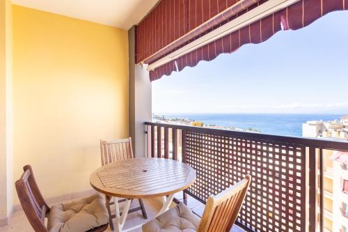 ein Balkon mit Tisch und Stühlen und dem Meer in der Unterkunft Home2Book Seaside Escape Playa La Arena in Puerto de Santiago