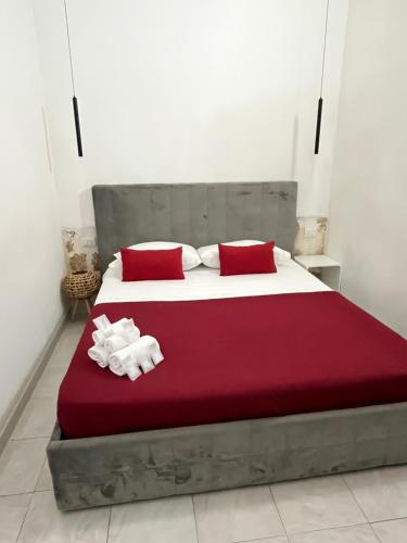 sypialnia z dużym łóżkiem z czerwonymi poduszkami w obiekcie B&B Regina Rooms w mieście Avola