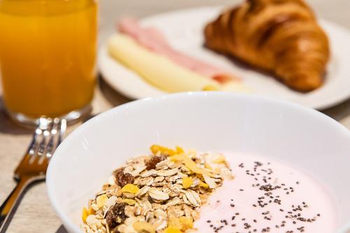 a plate of food on a table with bread and orange juice at Hotel ibis Lisboa Saldanha in Lisbon