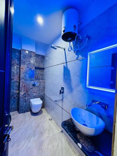 a blue bathroom with a sink and a toilet at KashVi Hotels in Varanasi