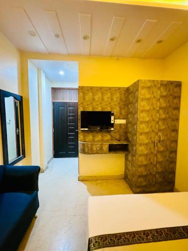 a living room with a couch and a tv on a wall at KashVi Hotels in Varanasi