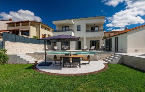 リジュニャンにあるVilla Cascadaの家の前にテーブルと傘付きのパティオ