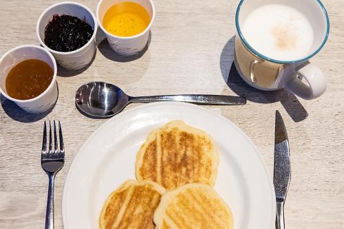 a white plate with toast and two cups of coffee at Hotel ibis Lisboa Saldanha in Lisbon