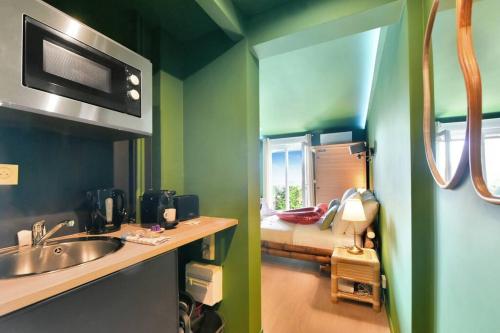 une salle de bain avec un lavabo et une chambre avec un lit dans l'établissement The Jungle - Jacuzzi, Sauna & Projector, à Cannes