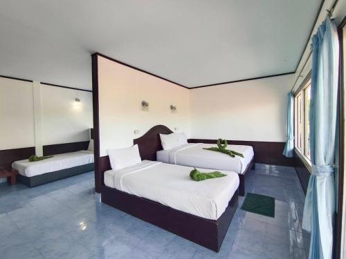 a bedroom with two beds with white sheets at Phi Phi View Point Resort in Phi Phi Don
