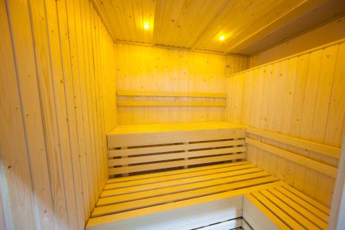 a sauna with yellow wood paneling and wooden shelves at Heacham Manor Hotel in Hunstanton