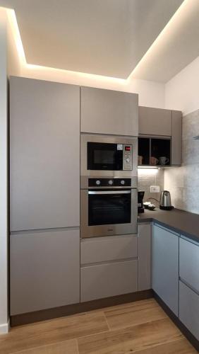 a kitchen with stainless steel appliances and white cabinets at Lacugnano Apartment La tua casa in umbria in Perugia