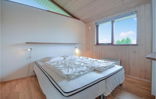 a bedroom with a bed in a room with a window at Holiday Home Valmuevej Rønde Ix in Rønde