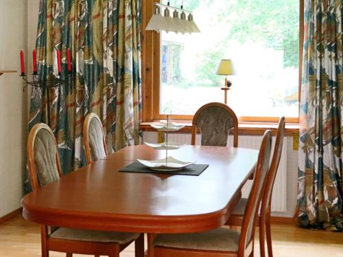 a dining room with a wooden table and chairs at 4 star holiday home in Unnaryd in Unnaryd