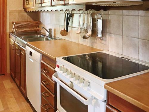 a kitchen with a stove and a sink at 4 star holiday home in Unnaryd in Unnaryd