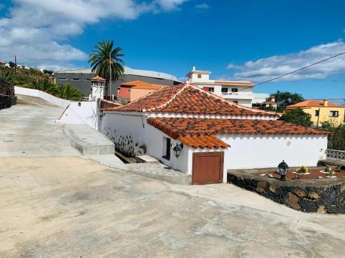 una casa blanca con techo de tejas rojas en Casa El Pajero, en Breña Alta