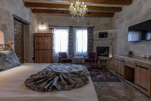 a bedroom with a large bed with a blanket on it at Göreme Cave Suites in Goreme
