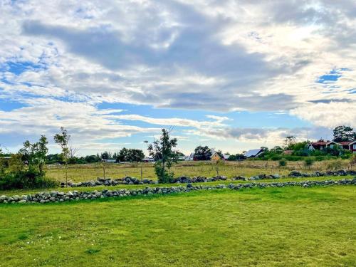 a group of rocks in a field under a cloudy sky at 4 person holiday home in LÖTTORP in Löttorp