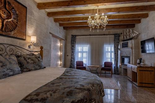a bedroom with a large bed with a chandelier at Göreme Cave Suites in Goreme