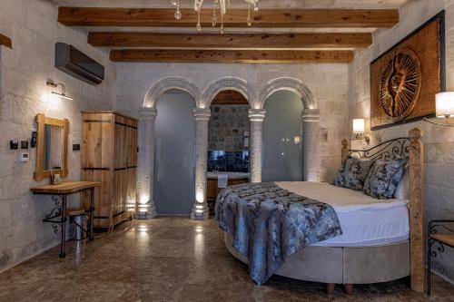 a bedroom with a bed and a table in a room at Göreme Cave Suites in Goreme