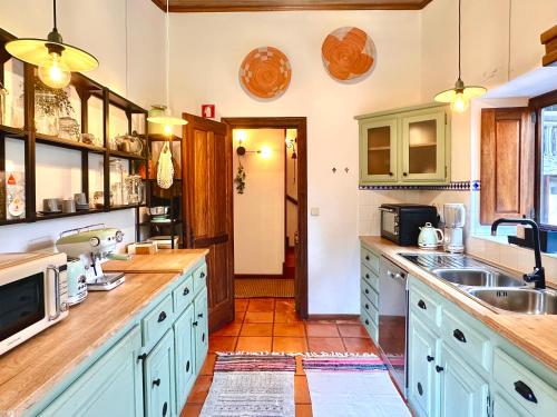 a kitchen with blue cabinets and a sink at Villa Esquina 204 - Connected With Nature- uChill in Riba de Âncora