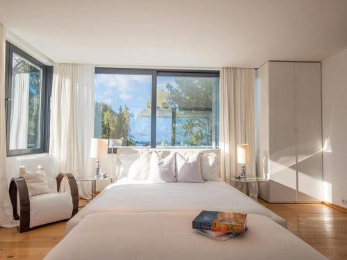 a bedroom with a large bed with a large window at Villa in Ibiza near Salinas Beach in Sant Llorenç de Balafia