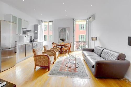 un salon avec un canapé en cuir et une cuisine dans l'établissement Rue Fodere location Port area, à Nice