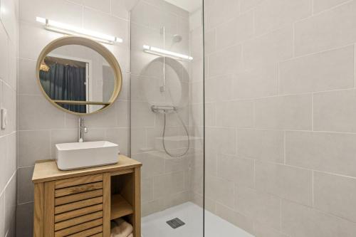 ein Badezimmer mit Dusche, Waschbecken und Spiegel in der Unterkunft Appartement Le Lavandou - Cavalière in Le Lavandou