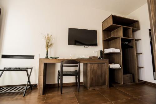 a room with a desk with a chair and a tv at Ddò Relais di Puglia in Ostuni